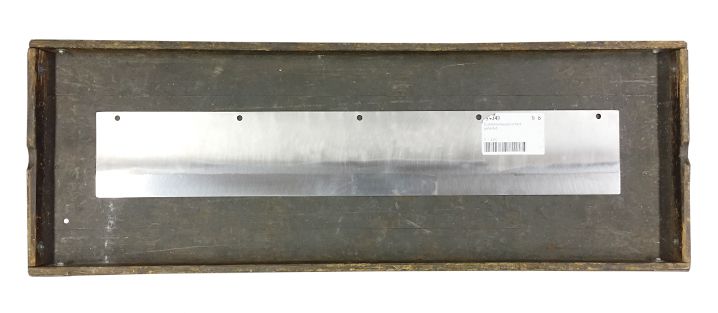 Grosse Klinge / Messer als Teil einer Maschine, auf einem Holzbrett.