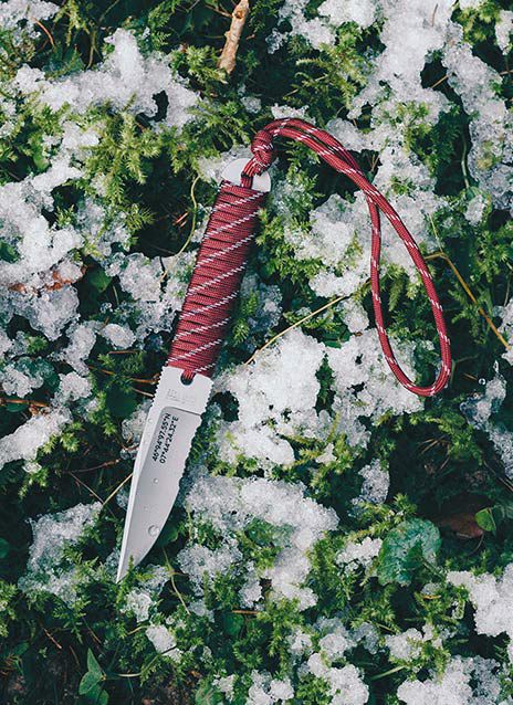 Das von BRGGR gestaltete Klötzli Messer fotografiert auf Waldboden mit Schnee.